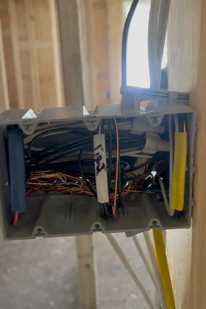 A multi-gang device box in an open wall with conductors pulled in and tagged